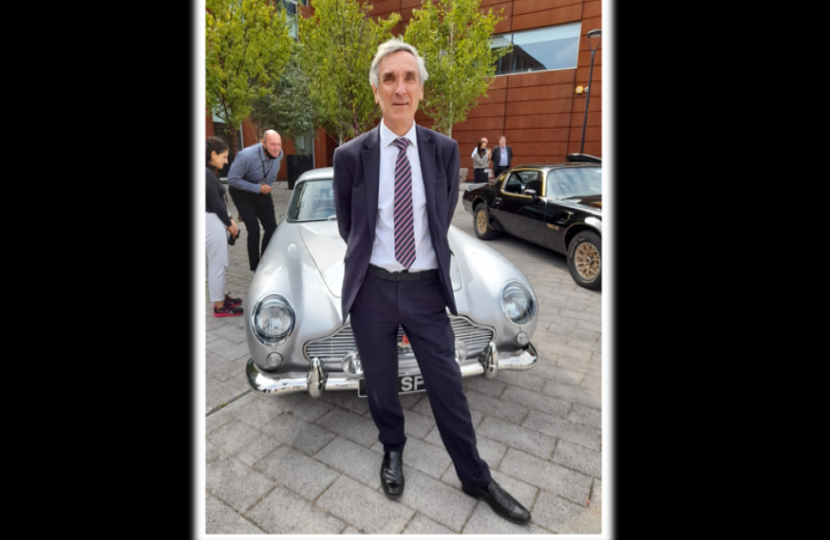 John in front of a bond car
